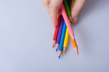 Beyaz arkaplana yerleştirilmiş el ele tutuşan kalemler