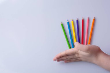 Beyaz arkaplana yerleştirilmiş el ele tutuşan kalemler