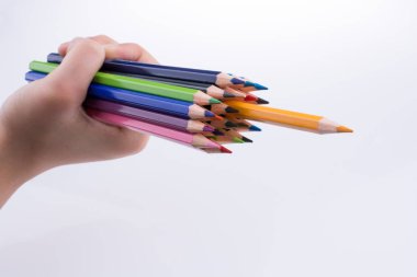 Beyaz arkaplanda el ele tutuşan renkli kalemler