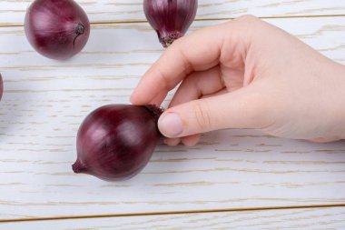 Tüm kırmızı soğan soğanları kahverengi ve ahşap arka planda
