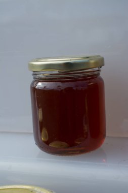 Kapaklı taze bal dolu cam kavanoz.