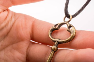 Beyaz arka planda bir anahtar tutan el.