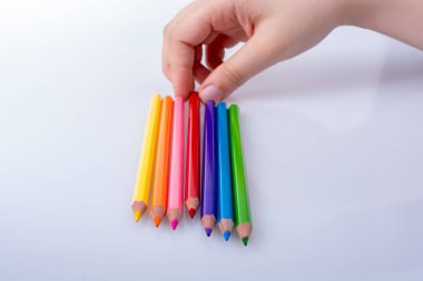 Beyaz arkaplana yerleştirilmiş el ele tutuşan kalemler