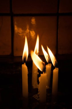 Karanlıkta mum ışığında yanan mumlar.