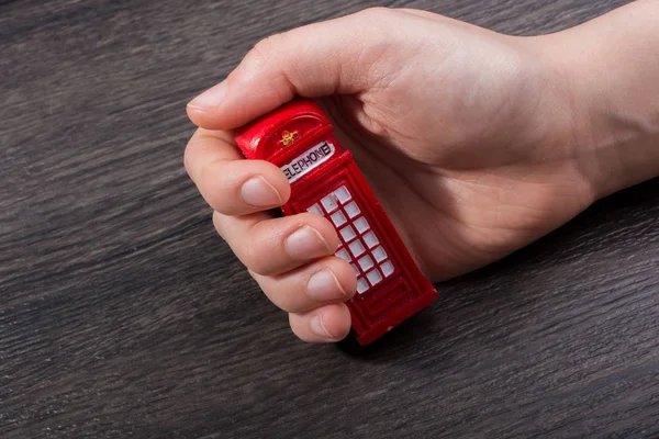 Mano Sosteniendo Una Cabina Telefónica Sobre Fondo Marrón — Foto de Stock