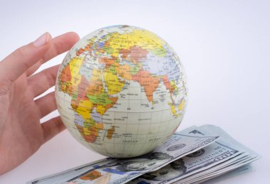 İnsan eli aamerican Doları banknot beyaz arka plan üzerinde yan tarafından bir model küre tutan