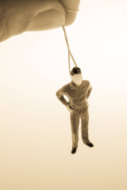 Kahverengi backgorund aa ipi ile bağlı adam heykelcik