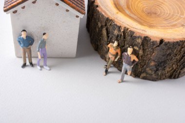 Adam minyatür bir ev ve bir ağaç önce küçük heykelcik