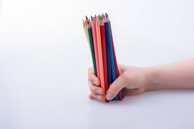 Beyaz arkaplana yerleştirilmiş el ele tutuşan kalemler