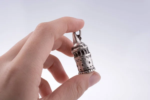 Hand holding a Galata Tower model on a white background