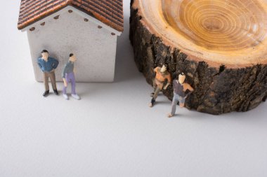 Adam minyatür bir ev ve bir ağaç önce küçük heykelcik