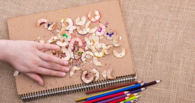 Kahverengi bir arka plan üzerine yerleştirilen renkli kalemler