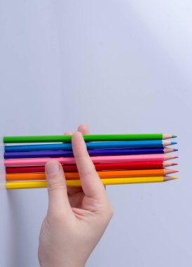 Beyaz arkaplana yerleştirilmiş el ele tutuşan kalemler