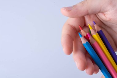 Beyaz arkaplana yerleştirilmiş el ele tutuşan kalemler