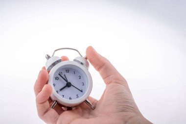 Beyaz arkaplan üzerindeki alarmlı saat