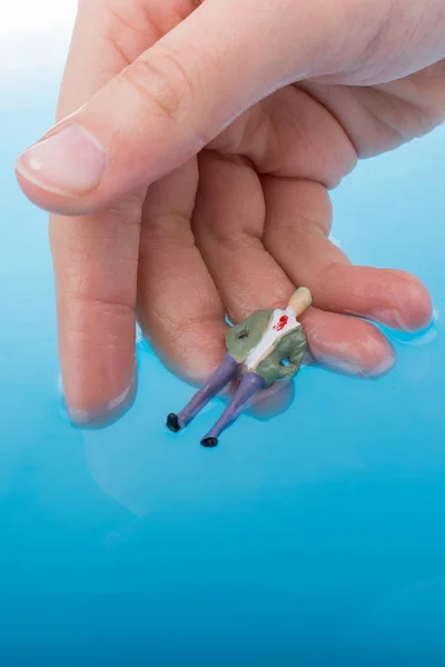 Ręka Trzyma Człowieka Figurki Wodzie Boku Mały Dom Modelu — Zdjęcie stockowe