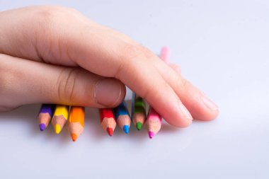 Beyaz arkaplana yerleştirilmiş el ele tutuşan kalemler