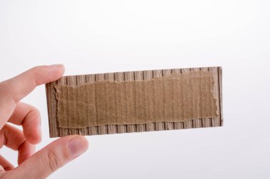 Beyaz bir arka plan üzerinde bir kesim karton kağıt tutan el