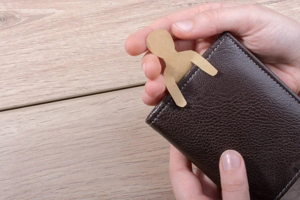 Man shape cut out of paper in wallet in hand