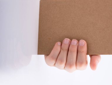 Beyaz arkaplanda kahverengi renkli bir not defteri var.