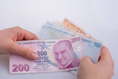 Turksh Lirası banknotlar beyaz arka plan üzerinde tutan el