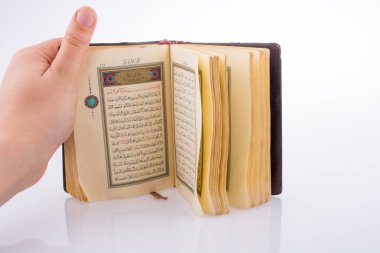 Beyaz arka planda Kuran 'ı el ele tutuşarak.