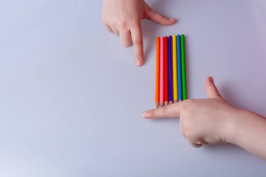 Beyaz arkaplana yerleştirilmiş el ele tutuşan kalemler