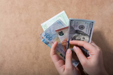 El ele tutuşan Amerikan doları banknotları ahşap arka planda izole edilmiş.