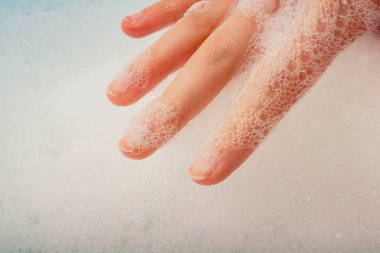 Köpüklü arka planda el yıkama ve sabun köpüğü.