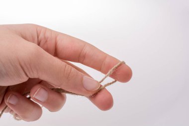 Keten iplik beyaz bir arka plan üzerinde tutan el