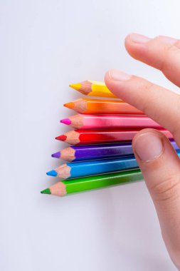 Beyaz arkaplana yerleştirilmiş el ele tutuşan kalemler