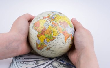İnsan eli aamerican Doları banknot beyaz arka plan üzerinde yan tarafından bir model küre tutan