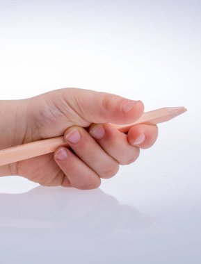 Beyaz bir arka plan üzerinde renkli kalem tutan el