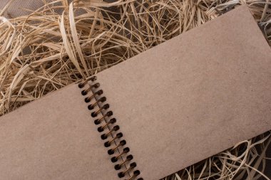 Hasır bir arka plan üzerine yerleştirilen spiral defter