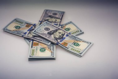 Beyaz zemin üzerine yerleştirilmiş Amerikan 100 dolarlık banknot demetleri