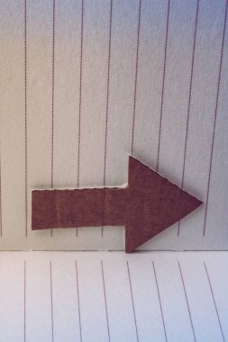 Heykelcik ve tuval üzerine bir defter kağıt ok