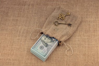 Retro anahtar ve bir çuval dolusu Amerikan doları tuvalde.