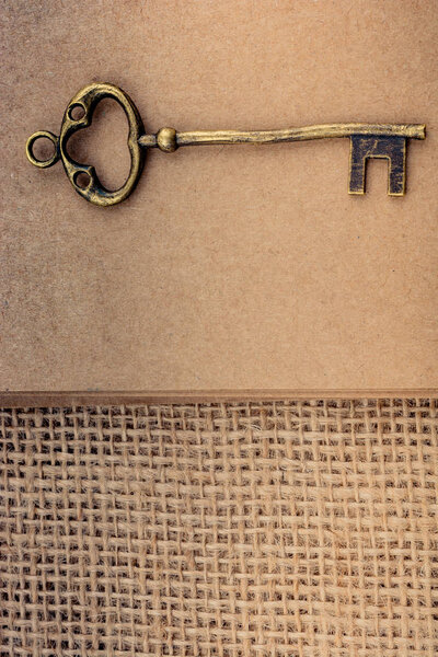 Retro styled golden color key on a linen canvas in view
