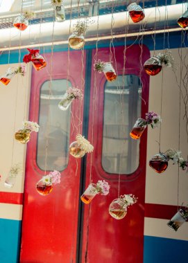 İplere asılı çiçekli bitkisel çay şişeleri