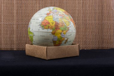 Üzerinde harita olan bir küreyi tutan el.