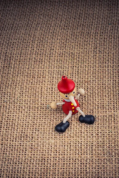 Bambola Pinocchio Legno Seduta Sfondo Tela — Foto Stock