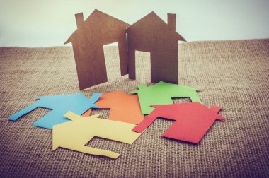 Tuvalin arka planında renkli kağıttan kesilmiş küçük bir ev şekli