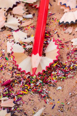 Kalem talaşlarının üzerine kırmızı renkli kalem.