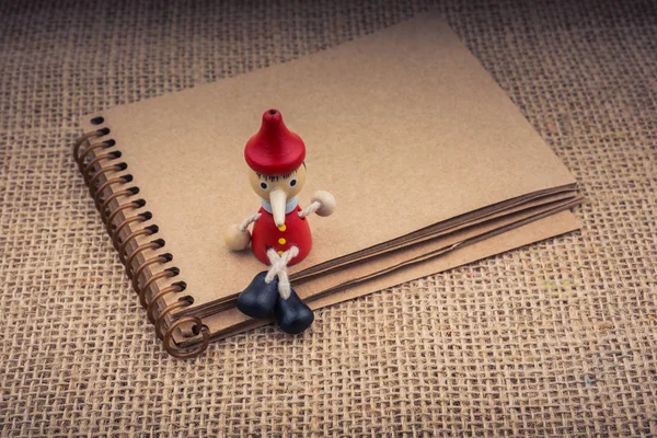 Pinocchio Sedící Notebook Pozadí Plátno — Stock fotografie