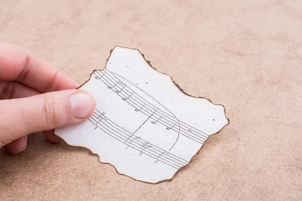 Hand Holding Burnt Paper Musical — Stock Photo, Image