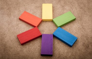 Çeşitli renklerin ahşap bloklarından birini tutarken