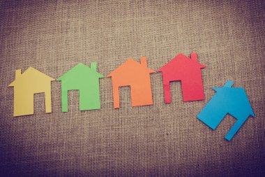 Tuvalin arka planında renkli kağıttan kesilmiş küçük bir ev şekli