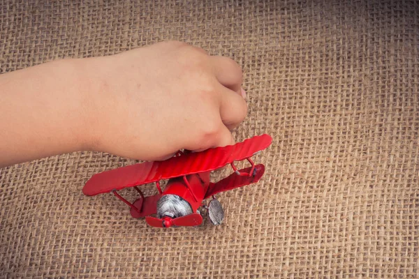 Mão Segurando Avião Brinquedo Vermelho Uma Tela Linho — Fotografia de Stock
