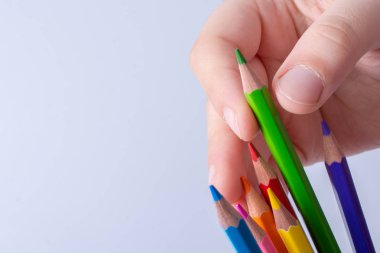 Beyaz arkaplana yerleştirilmiş el ele tutuşan kalemler