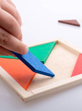 Tangram bulmacasının kayıp parçasını tutan el.